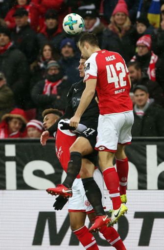 Die Mainzer Jean-Philippe Gbamin (links) und Alexander Hack (rechts) und Stuttgarts Mario Gomez kämpfen um den Ball. Foto: dpa